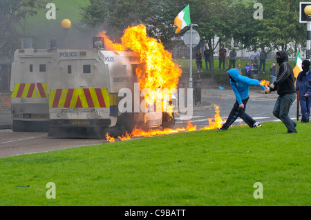 Nazionalista mascherato giovani gettare bombe molotov a PSNI veicoli durante i tumulti in Bogide, Londonderry. Foto Stock