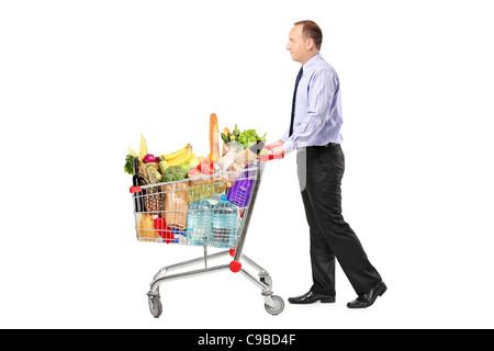 Persona spingendo un carrello pieno di negozi di generi alimentari Foto Stock