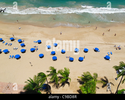 Angolo di Alta Vista di una spiaggia con Umbreallas e palme, il Condado Beach, San Juan, Puerto Rico Foto Stock