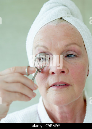 Senior donna la sagomatura di ciglia con ciglia, arricciatore close up Foto Stock