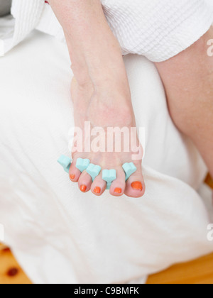 Senior donna pittura toenails, close up Foto Stock