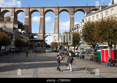 Persone che camminano nella Place des Otages con il viadotto in background in Morlaix, Finisterre, Brittany, Francia. Foto Stock