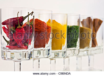 Selezione di spezie in bicchieri contro uno sfondo bianco Foto Stock
