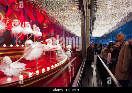 Parigi, Francia, una folla di gente che cerca in Le Printemps Department Store in Windows, godendo le luci di Natale, Visualizza, negozio finestra anteriore, di notte sulla strada Foto Stock