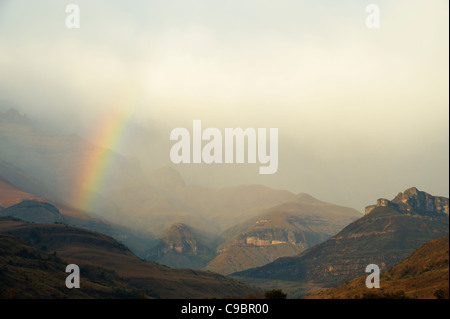 Rainbow alla base della gamma di anfiteatro nelle montagne Drakensberg, Royal Natal, Kwazulu-Natal, Sud Africa Foto Stock