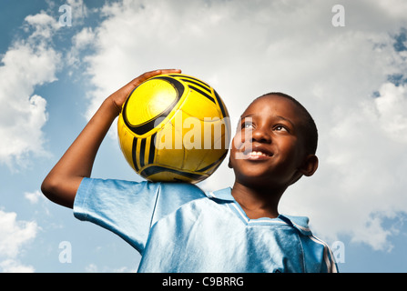 Ragazzo tenendo il calcio all'aperto, Johannesburg, provincia di Gauteng, Sud Africa Foto Stock