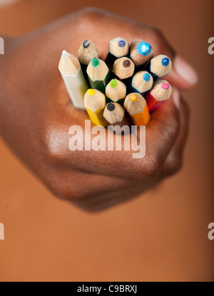 Childs mano in presa matite colorate, Johannesburg, provincia di Gauteng, Sud Africa Foto Stock