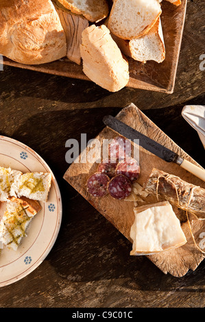 Piatti tipici della cucina italiana, salame, bruschette, pane, formaggio, olio d'oliva, su un rustico tavolo di legno, Umbria, Italia Foto Stock