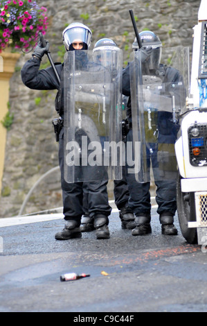 PSNI ufficiali traggono il loro manganelli durante disordini nel Bogside, Londonderry, Irlanda del Nord, a seguito di una parata di lealisti. Foto Stock
