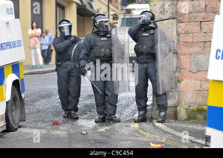 PSNI ufficiali traggono il loro manganelli durante disordini nel Bogside, Londonderry, Irlanda del Nord, a seguito di una parata di lealisti. Foto Stock