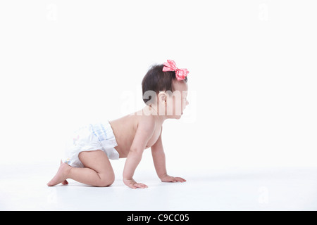 Baby girl nel pannolino gattona Foto Stock
