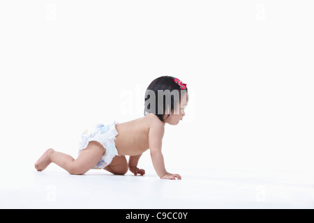 Baby girl nel pannolino gattona Foto Stock