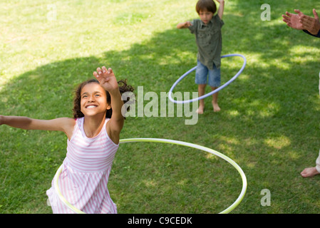 Ragazza che gioca con il cerchio in plastica Foto Stock