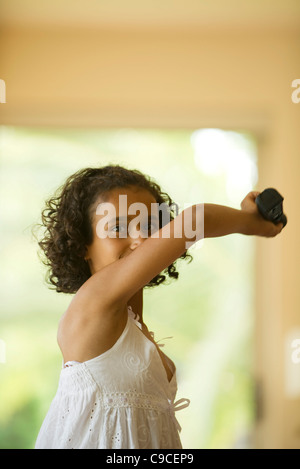 Ragazza la riproduzione del video gioco usando il controller wireless Foto Stock