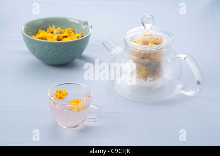 Teiera e una tazza di tè di tarassaco e i suoi fiori secchi Foto Stock