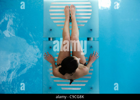 Donna relax sulla piscina passerella Foto Stock