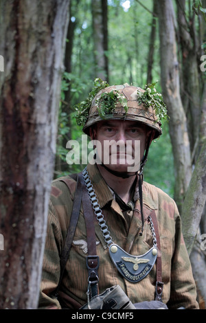 Un soldato tedesco in camuffamento (re-enactor) al 2011 Guerra e Pace mostra al luppolo in fattoria, Paddock Wood, Kent, Regno Unito. Foto Stock