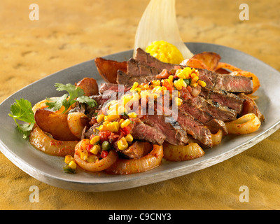 Le fajitas bistecca servita con verdure e patate e condito con una salsa di mais Foto Stock