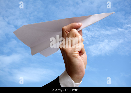 Uomo d affari con aeroplano di carta contro il cielo blu Foto Stock