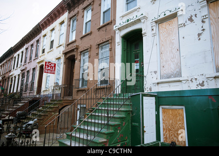 Fatiscenti case di arenaria e case in vendita su Van Buren Street nel quartiere Bedford-Stuyvesant di Brooklyn a New York Foto Stock