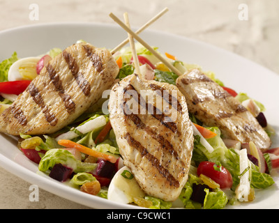 Pollo grigliato con insalata di lattuga e uovo, carote, pomodoro e cipolla con una medicazione Foto Stock