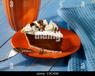 Una fetta di crema di cioccolato torta guarnita con panna montata e riccioli di cioccolato Foto Stock