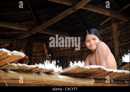 Embera ragazza indiana che sorride e che si trova nella sua capanna, Panama Foto Stock