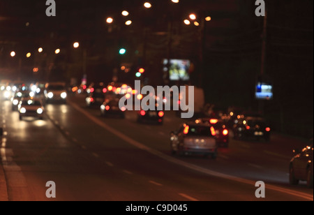 Defocalizzata scena notturna di semafori e automobili. Foto Stock