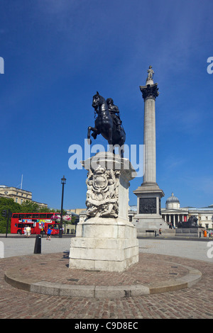 Statua equestre di Carlo I e Nelson's colonna in Trafalgar Square, un sole estivo, Londra, Inghilterra, UK, Regno Unito, Foto Stock