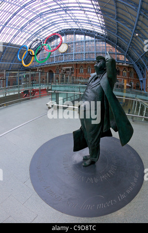 Statua di Sir John Betjeman davanti gli anelli olimpici Logo, nel terminal Eurostar della stazione di Kings Cross St Pancras stazio ferroviaria Foto Stock