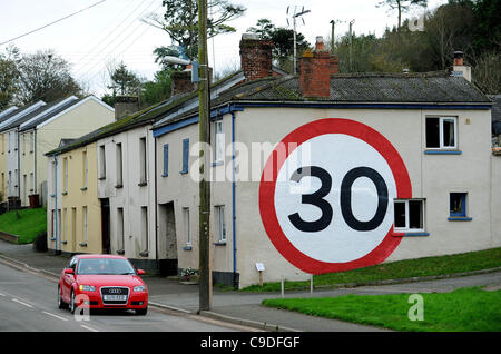 23.11.11. Un gigantesco dipinto 30mph segno su strada sul lato di una casa a rallentare il traffico attraverso il villaggio di prua in Devon, Inghilterra Foto Stock