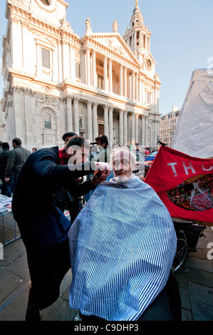 Il taglio di capelli a occupare Londra campeggio di protesta al di fuori di St Pauls Cathedral Londra centrale Foto Stock