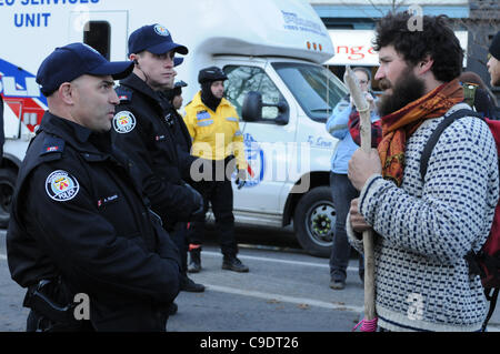 Novembre 23, 2011, che avvolge lo sfratto, uno di Toronto il servizio di polizia di Constable parla direttamente con un manifestante in Adelaide Street, tra centinaia di altre forze di polizia, i sostenitori di protesta, città i lavoratori e le persone di media a St. James Park. La polizia di Toronto, servizio comunale personale di opere e di protesta Foto Stock