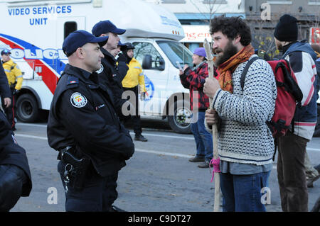 Novembre 23, 2011, che avvolge lo sfratto, uno di Toronto il servizio di polizia di Constable parla direttamente con un manifestante in Adelaide Street, tra centinaia di altre forze di polizia, i sostenitori di protesta, città i lavoratori e le persone di media a St. James Park. La polizia di Toronto, servizio comunale personale di opere e di prote Foto Stock