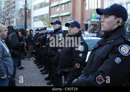 Novembre 23, 2011, che avvolge lo sfratto, Toronto servizio di polizia poliziotti formano una linea sul marciapiede di Adelaide Street, i sostenitori di protesta dei lavoratori della città e la media di persone a St. James Park. La polizia di Toronto, servizio comunale personale di opere e di protesta coordinatori sono tutti vincere alte lodi f Foto Stock