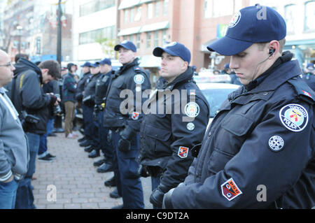 Novembre 23, 2011, che avvolge lo sfratto, Toronto servizio di polizia poliziotti formano una linea sul marciapiede di Adelaide Street, i sostenitori di protesta dei lavoratori della città e la media di persone a St. James Park. La polizia di Toronto, servizio comunale personale di opere e di protesta coordinatori sono tutti vincere alte lodi f Foto Stock