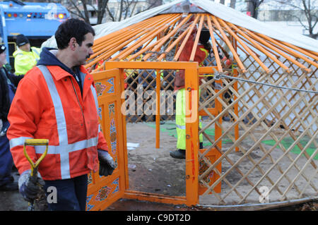 Novembre 23, 2011, che avvolge lo sfratto, due Toronto City lavoratori visto qui, circondati dalla polizia, protesta sostenitori e media people, smantellare la libreria yurt, l'ultimo residuo occupano la struttura di movimento a St. James Park. La polizia di Toronto, servizio comunale personale di opere e di protesta coord Foto Stock