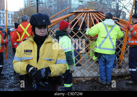 Novembre 23, 2011, che avvolge lo sfratto, Toronto City lavoratori, circondato da forze di polizia, i sostenitori di protesta e media people, smantellare la libreria yurt, l'ultimo residuo occupano la struttura di movimento a St. James Park. La polizia di Toronto, servizio comunale personale di opere e coordinatori di protesta sono al Foto Stock