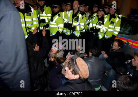 30 Nov 2011, Haymarket, Londra. I manifestanti tentano di bloccare la strada per impedire ad un veicolo di polizia lasciando che contengono i detenuti che sono stati arrestati durante la breve occupazione della Panton House di Londra. Il sedersi protesta fu breve e le forze di polizia rapidamente allontanato i manifestanti. Foto Stock