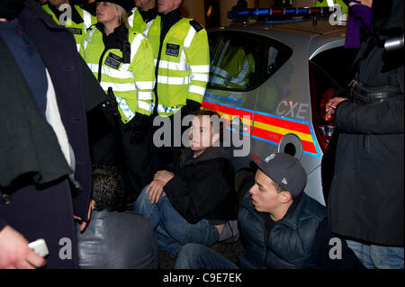 30 Nov 2011, Haymarket, Londra. I manifestanti tentano di bloccare la strada per impedire ad un veicolo di polizia lasciando che contengono i detenuti che sono stati arrestati durante la breve occupazione della Panton House di Londra. Il sedersi protesta fu breve e le forze di polizia rapidamente allontanato i manifestanti. Foto Stock