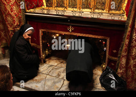 16 dic 2011 - Betlemme, West Bank, Territorio palestinese - una suora prega presso la grotta della Chiesa della Natività, il tradizionale luogo di nascita di Gesù Cristo, in Cisgiordania città di Betlemme Dicembre 15, 2011, in anticipo di Natale. Per i fanatici del cristiano ha iniziato la loro spirituale preparativi in vista Foto Stock