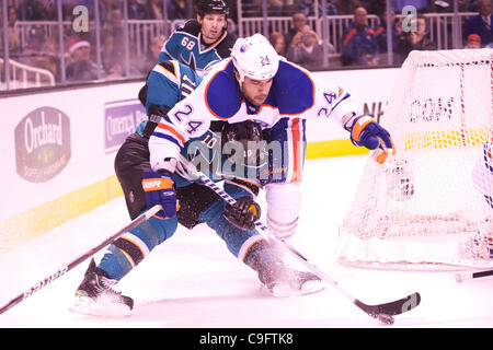 Dic. 17, 2011 - San Jose, California, Stati Uniti - Squali ala sinistra Brad Winchester (10) scherma il puck da lubrificatori defenceman Theo Peckham (24) durante il gioco NHL tra gli squali di San Jose e i lubrificatori de Edmonton in HP Pavilion a San Jose, CA. Le squadre sono legato dopo il primo periodo. (Credito Imag Foto Stock