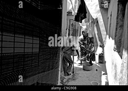 Sett. 27, 2010 - Kano, Kano, NIGERIA - Mentre è appesa appena lavato i vestiti, Khadija Aminu paralizzata per molti anni con la poliomielite, parla a suo figlio Umar, 8, anche storpio con la poliomielite in casa loro a Kano, Nigeria. Fuori di sette figli, Umar è il solo con la poliomielite. Umar il padre è il Sig. Aminu Ahmen E Foto Stock