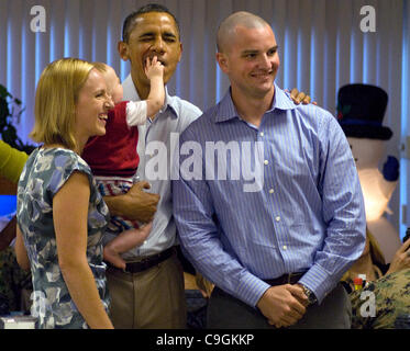 Il giovane figlio di Capt. Greg Wagner scherzosamente afferra il Presidente Barack labbra durante una foto a Anderson Hall Dining Facility, Dicembre 25, 2011 in Kaneohe, Hawaii. Il presidente e la first lady Michelle Obama, ha salutato Marines, i marinai e i civili a bordo Marine Corps base Hawaii il giorno di Natale. Foto Stock