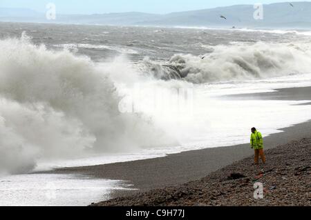 Regno Unito, alta venti pastella il paese, uomo lotte contro il vento a Chesil Beach nel Dorset. 030112 Immagine: Dorset Media Service. Foto Stock