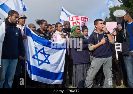 Migliaia di Etiopi e sostenitori join Hararo Mulet, che figurano su un 70Km in 3 giorni di trekking a Gerusalemme dalla sua casa in Kiryat Malachi, al Wohl Rose Garden di fronte alla Knesset che protestavano il razzismo. Gerusalemme, Israele. 18 gennaio 2012. Foto Stock