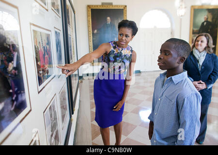 La First Lady Michelle Obama mostra NFL Super Kid James Gale, 11, foto storiche da precedenti amministrazioni sul display nell'area di librai durante un National Football League taping nell Ala Est della Casa Bianca 30 Gennaio 2012 a Washington, DC. Foto Stock