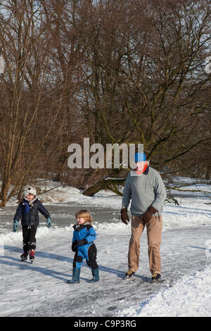 Big freeze: persone pattinaggio sul ghiaccio nel Parco di Vondel Amsterdam, febbraio 2012. Per tutta la notte a temperature basse come -18 ha lasciato la città di canali e stagni congelati - e l'olandese non perdete la possibilità di indossare i loro pattini da ghiaccio. Foto Stock