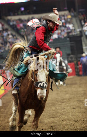 Un cowboy rides in cima a strappi cavallo durante il "mondo Rodeo più difficili' concorrenza all'Xcel Energy Center di St Paul, Minnesota, 4 febbraio 2012. Foto Stock