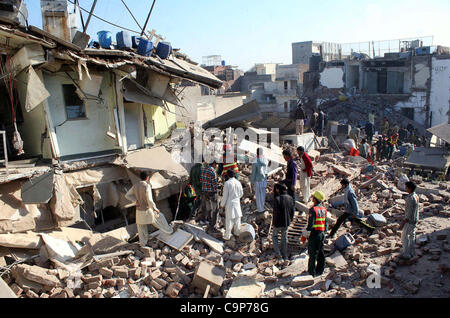 Gli operatori di soccorso look per i sopravvissuti di detriti in corrispondenza del sito di crollo dell'edificio incidente a Lahore Lunedì, 06 febbraio 2012. Foto Stock